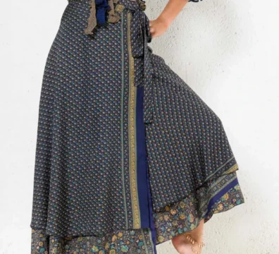 Jupe longue portefeuille bleue à imprimé floral et bordure dorée, style bohème chic.