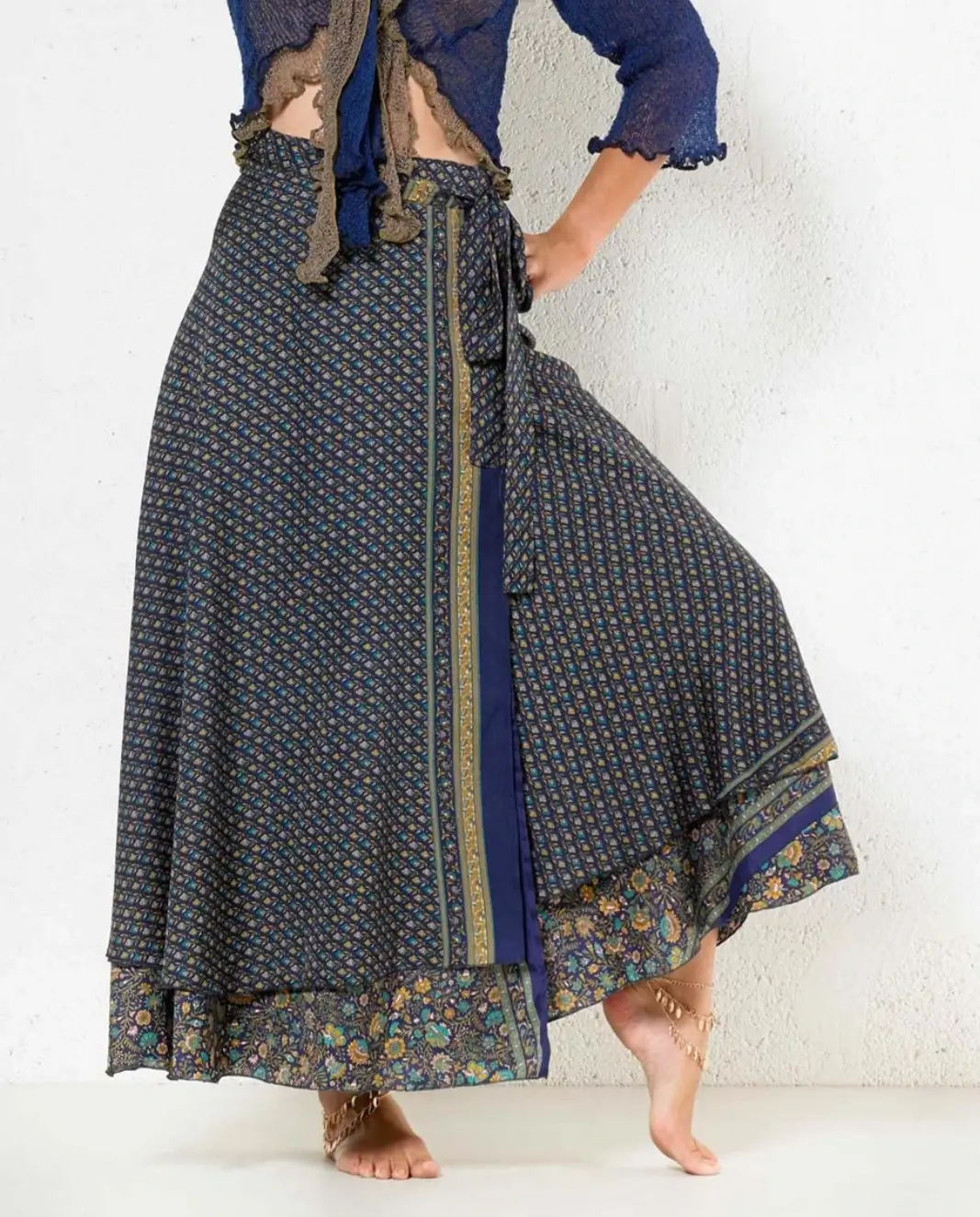 Jupe longue portefeuille bleue à imprimé floral et bordure dorée, style bohème chic.