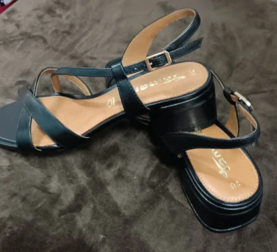 Sandales noires à brides croisées avec talon carré moyen et boucle réglable à la cheville.