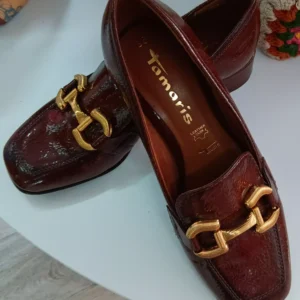 Paire de mocassins en cuir marron verni Tamaris avec boucle dorée.